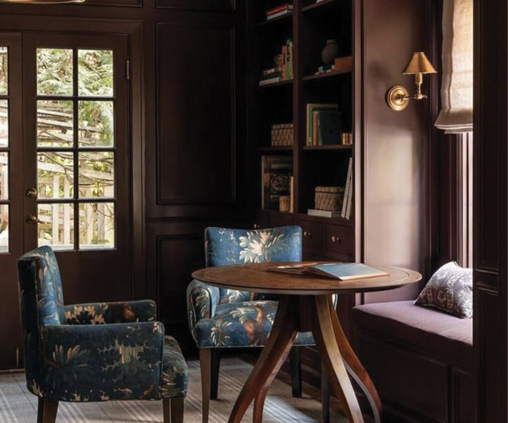 Traditional-style reading nook with two chairs and round wood side table.